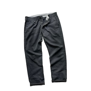 Puede incluir: Un pantalón gris oscuro con cierre de botón y dobladillo.