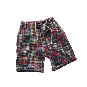 Könnte beinhalten: Rote, blaue und gelbe karierte Shorts mit Patchwork-Design. Die Shorts haben einen Kordelzugbund und eine lockere Passform.