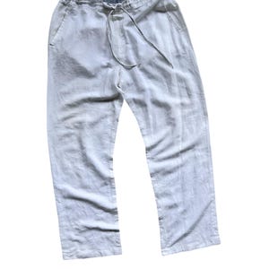 May include: White linen pants with a drawstring waist and side pockets.