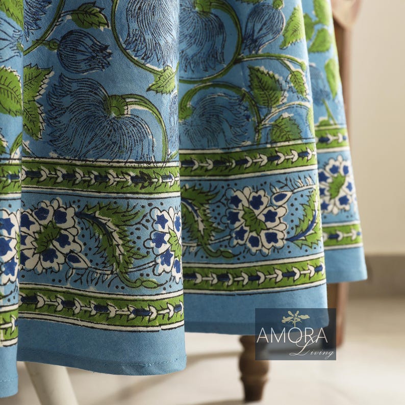 May include: A blue and green floral tablecloth with a white border. The tablecloth has a traditional Indian design.