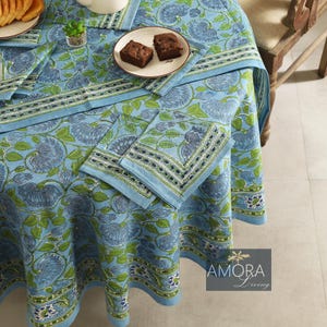 May include: A blue and green floral tablecloth with a white border. The tablecloth is round and has a diameter of approximately 70 inches. The tablecloth is made of cotton and is perfect for a casual dining setting.