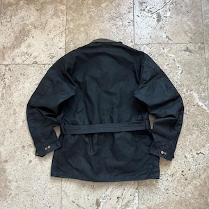 Peut inclure: Une veste noire ceintur&eacute;e avec un col marron et deux boutons de fermeture sur chaque poignet.
