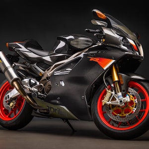 May include: A black and silver sport motorcycle with red and orange accents. The motorcycle has a carbon fiber body and gold wheels with red rims. The motorcycle is on a black background.