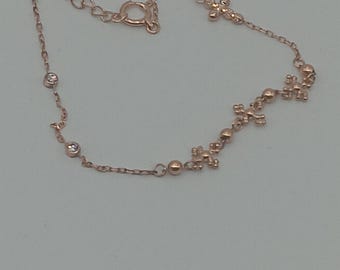 May include: Rose gold bracelet featuring a delicate chain with small cross and bead accents. The bracelet includes a lobster clasp closure and a small extension chain for adjustable sizing. The jewelry is displayed on a neutral background.
