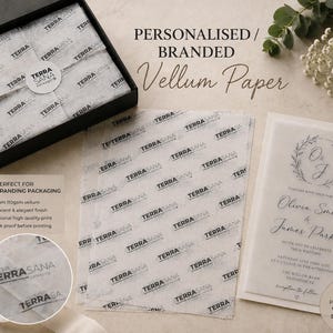 May include: A black box containing white vellum paper printed with the repeating black text TERRASANA, alongside loose sheets of the same branded vellum paper and a translucent wedding invitation featuring the initials O and J in a wreath.