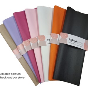May include: A selection of tissue paper colours, including brown, lavender, pink, light pink, white, orange, and black. The tissue paper is folded and arranged in a fan shape. The text "TERRASANA" is visible on the black tissue paper.