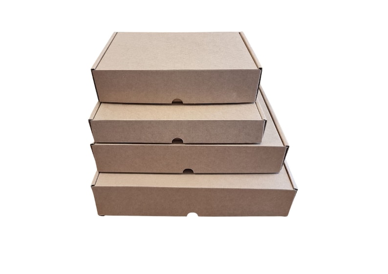 May include: A stack of four rectangular cardboard shipping boxes in a natural brown color. Each box features a flat lid, a sturdy construction, and a small semi-circular cutout on the front edge for easy opening and secure closure of the container.