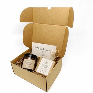 Candle & soap box:
Brown Kraft postal box filled with a candle, handmade soap, thank you card and paper shred, styled as small business gift packaging.