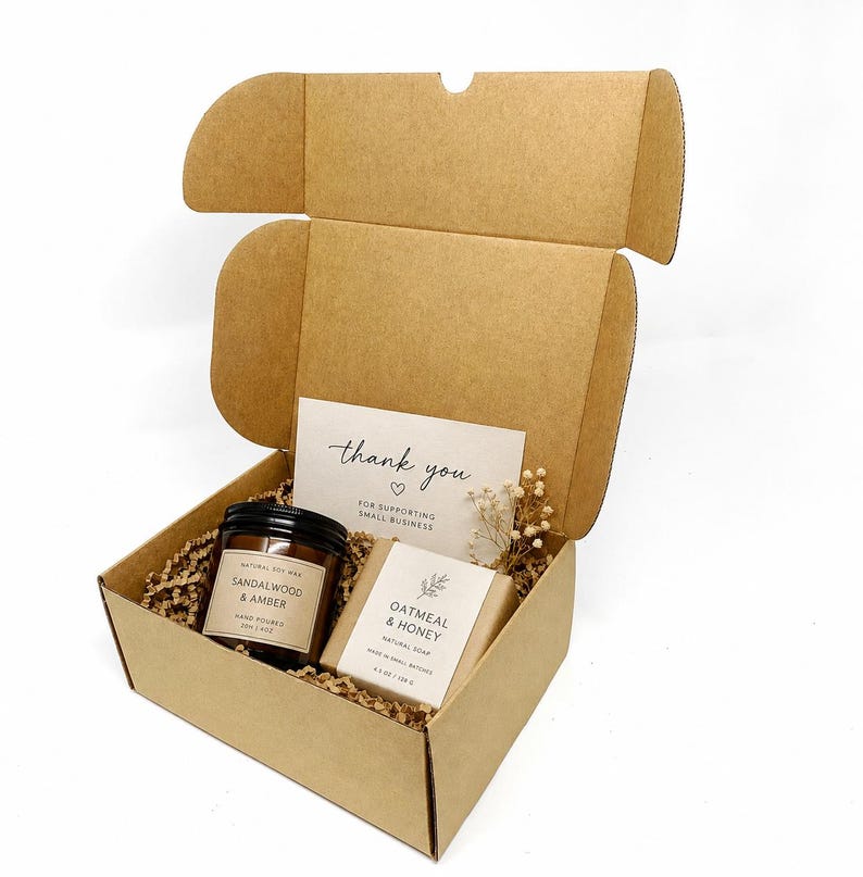 Candle & soap box:
Brown Kraft postal box filled with a candle, handmade soap, thank you card and paper shred, styled as small business gift packaging.