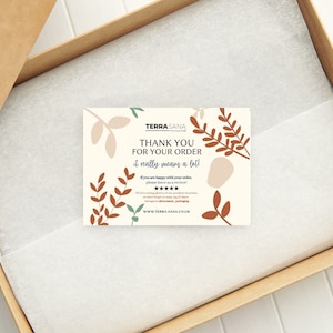 May include: A rectangular thank you card with a cream background and rust-colored leaf illustrations. The text reads: TERRA SANA, THANK YOU FOR YOUR ORDER, it really means a lot!, If you are happy with your order, please leave us a review!, five stars, and WWW.TERRA-SANA.CO.UK.