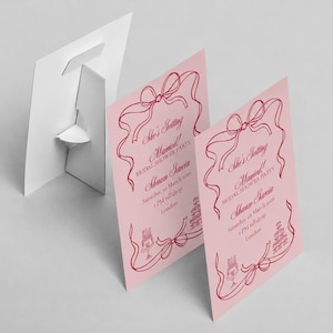 May include: Two light pink rectangular bridal shower signs with a dark pink ribbon border and illustrations of cakes. The text reads: She's Getting Married! BRIDAL SHOWER PARTY, Shawn Garcia, Saturday, 22 March 2026, 1 PM till drop, London.