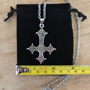 Pode incluir: Um colar com um pingente de prata em forma de cruz adornada. O colar mede 5 cm de comprimento e vem com uma bolsa de veludo preto.