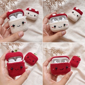 May include: Two crocheted Airpod cases, one red and one white, shaped like mushrooms with smiling faces. The cases are open to show the Airpods inside.