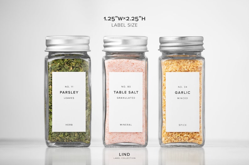 May include: Three glass spice jars with silver lids, each containing a different ingredient: parsley, table salt, and minced garlic. Each jar has a white label with the ingredient name and a measurement of 1.25"W x 2.25"H. The text "LIND LABEL COLLECTION" is at the bottom.