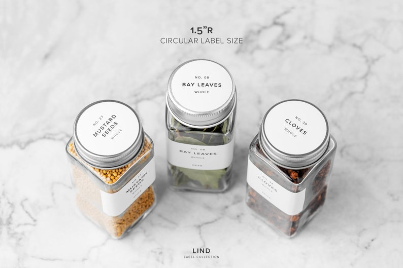 May include: Three clear glass jars with silver lids, each containing different spices: mustard seeds, bay leaves, and cloves. Each jar has a white label with black text. The text "1.5"R CIRCULAR LABEL SIZE" is at the top.