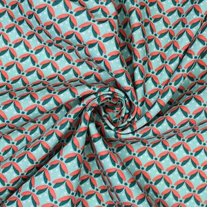 May include: Teal fabric with a repeating pattern of red and green stylised leaves. The fabric is folded and twisted.