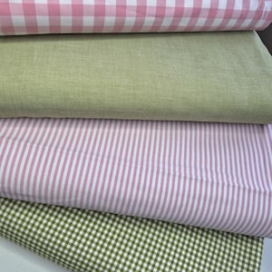 Puede incluir: Una pila de muestras de tela en varios patrones y colores. La capa superior presenta un estampado de cuadros rosa y blanco, seguida de una tela verde claro lisa. Debajo hay una tela a rayas rosa y blanca y una tela a cuadros verde y blanca.