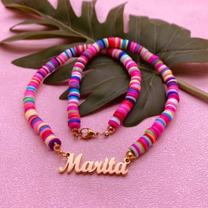 May include: A colorful multi-layered beaded necklace with a gold nameplate that reads "Marita".