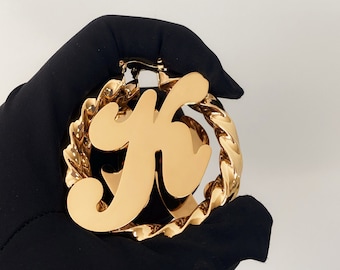 Op de afbeelding: Gouden creolen met een grote, dikke letter 'K' bedel. De bedel is in een vet, gestileerd lettertype.