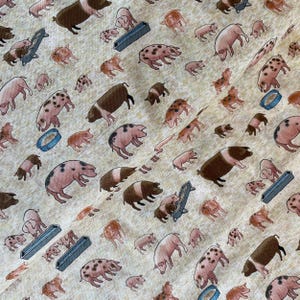 May include: A patterned fabric featuring cartoon pigs in shades of pink, brown, and spotted designs. The background is a light beige with a grassy texture, and there are blue feeding troughs. The design is repeated.