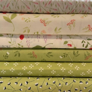 May include: A stack of six folded fabric bolts featuring various botanical patterns. The top three bolts have cream backgrounds with pink, green, and red floral prints. The bottom three bolts are green with white floral and geometric motifs.