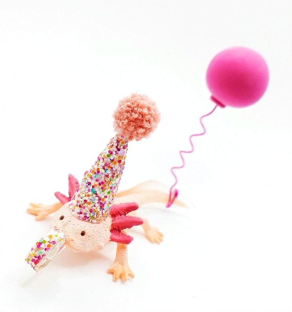A handcrafted axolotl cake topper wearing a tiny hat — absurdly specific, wildly charming, and 302 favorites confirm people are genuinely delighted by this.