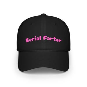 Peut inclure: Casquette de baseball noire avec une visière incurvée. Le texte "Serial Farter" est inscrit en rose sur le devant, dans une police légèrement vieillie. La casquette est faite d'un tissu durable et a une coupe structurée.