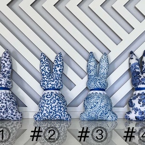 Peut inclure: Quatre lapins en peluche bleu et blanc &agrave; motifs. Les lapins sont num&eacute;rot&eacute;s de 1 &agrave; 4.