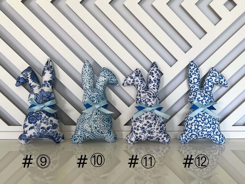 Peut inclure: Quatre lapins en peluche bleu et blanc &agrave; motifs avec des n&oelig;uds bleus. Les lapins sont num&eacute;rot&eacute;s de 9 &agrave; 12.