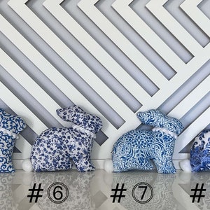 Peut inclure: Quatre peluches de lapin en forme de lapin bleu et blanc avec des pompons blancs sur la queue. Les lapins sont num&eacute;rot&eacute;s de 5 &agrave; 8.