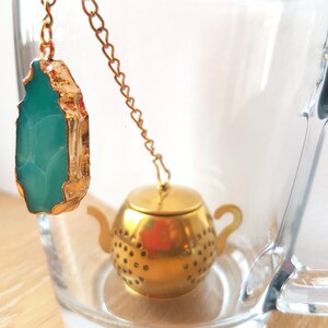 Peut inclure: Une infuseur &agrave; th&eacute; en forme de th&eacute;i&egrave;re dor&eacute;e avec une cha&icirc;ne et un pendentif en pierre pr&eacute;cieuse vert turquoise.
