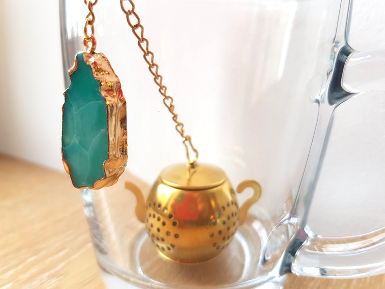 Peut inclure: Une infuseur &agrave; th&eacute; en forme de th&eacute;i&egrave;re dor&eacute;e avec une cha&icirc;ne et un pendentif en pierre pr&eacute;cieuse vert turquoise.