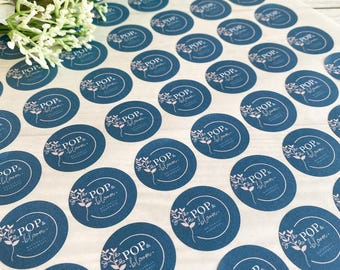 May include: A collection of round stickers with a dark teal background and white floral and text design. The text reads "POP & bloom. NATURALLY HANDMADE". The stickers are arranged in rows and columns on a white surface.