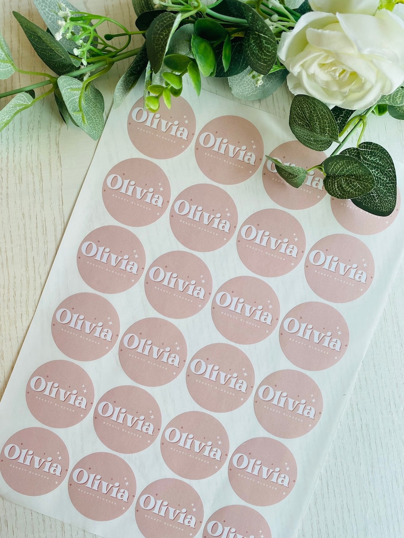 May include: A sheet of pink and white personalized stickers with the name "Olivia" printed on each sticker.