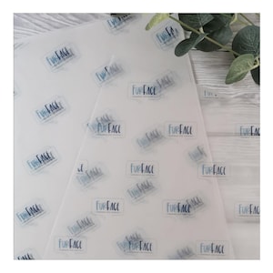 May include: White tissue paper sheets with a repeating pattern of the text "FURFACE" in a light blue speech bubble design. The paper is semi-transparent, and the design is visible on both sides. The paper is likely for handmade dog supplies.