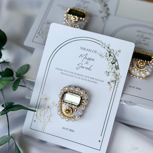 Personalized Islamic wedding favor featuring a digital tasbih counter attached to a custom Nikkah card with couple names and wedding date, elegant Muslim wedding guest gift display with floral design.