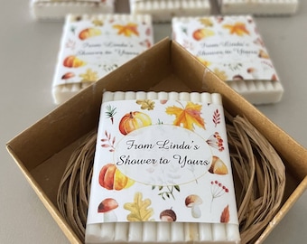 May include: A gift box containing several soaps with a fall theme. Each soap is wrapped with a label that reads "From Linda's Shower to Yours" and features pumpkins, leaves, and mushrooms. Two orange pumpkins are in the background.