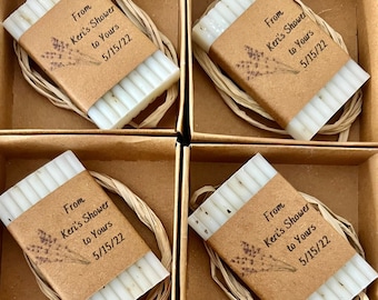 May include: Six small white soap bars wrapped in brown paper with a white string bow. Each bar has a label with the text "From Keri's Shower to Yours 5/15/22".