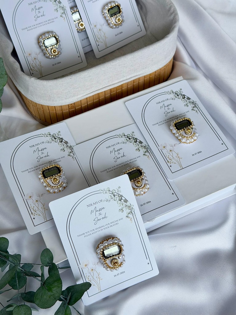 Personalized Islamic wedding favor featuring a digital tasbih counter attached to a custom Nikkah card with couple names and wedding date, elegant Muslim wedding guest gift display with floral design.