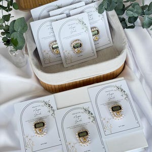 Personalized Islamic wedding favor featuring a digital tasbih counter attached to a custom Nikkah card with couple names and wedding date, elegant Muslim wedding guest gift display with floral design.