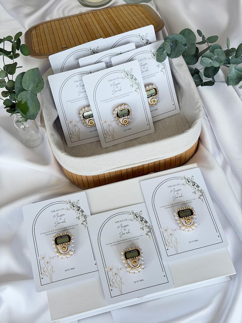 Personalized Islamic wedding favor featuring a digital tasbih counter attached to a custom Nikkah card with couple names and wedding date, elegant Muslim wedding guest gift display with floral design.