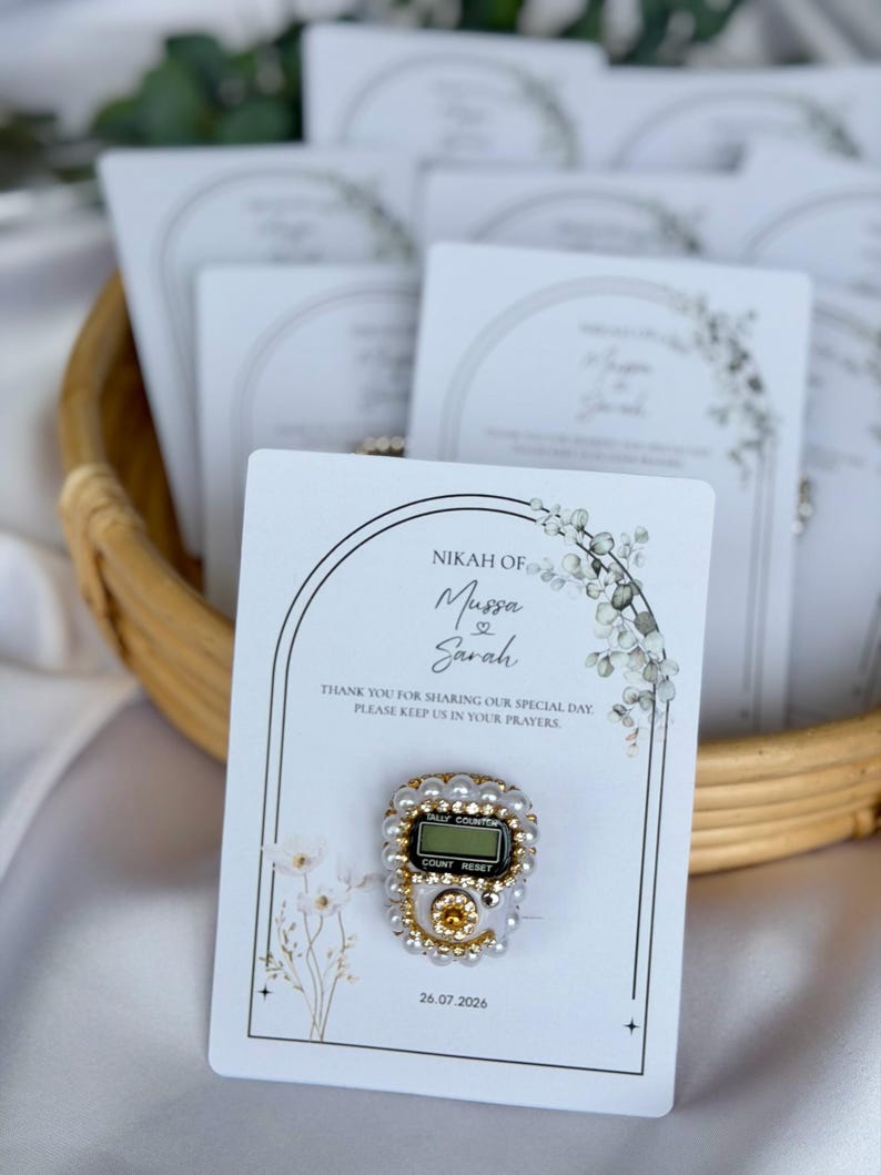 Personalized Islamic wedding favor featuring a digital tasbih counter attached to a custom Nikkah card with couple names and wedding date, elegant Muslim wedding guest gift display with floral design.