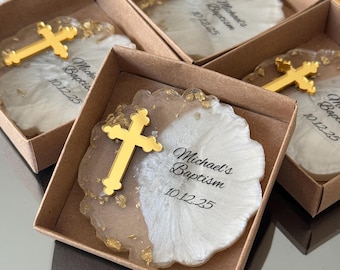 May include: A small white and gold resin cross with gold glitter and the text "Michael's Baptism 10.12.25" in a brown box.