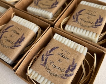 May include: Small brown boxes containing white soap bars wrapped in brown paper with a lavender design and the text "12.9.21 Adam & Crystal".