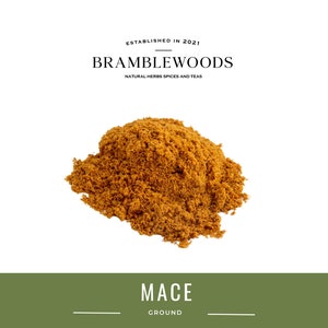 May include: A pile of ground mace spice, a light brown colour, on a white background. The text "MACE GROUND" is below the spice.