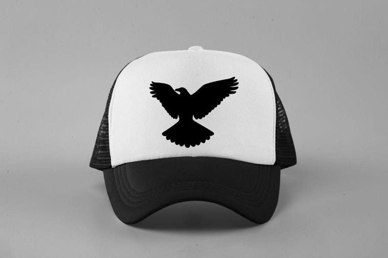 May include: A trucker hat featuring a white front panel with a black silhouette of a bird with wings spread wide. The hat has a solid black brim and black mesh side and back panels, with a button on the top center of the crown for a classic look.