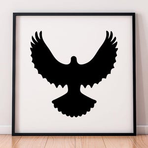May include: A square black frame containing a white print with a solid black silhouette of a bird in flight with its wings spread wide. The bird is centered in the frame, displaying a detailed feathered wing shape and a fanned tail design.