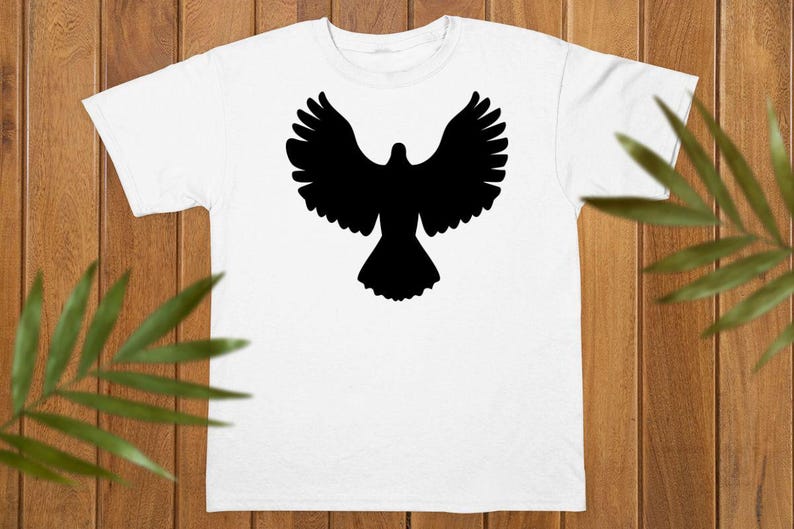 May include: A white short-sleeved t-shirt featuring a solid black silhouette of a bird with its wings spread wide in flight centered on the chest. The garment has a classic crew neckline and a straight hemline, providing a clean and simple look.