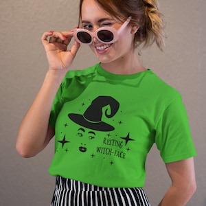 May include: A green t-shirt with a black witch graphic and the text "Resting Witch-Face".