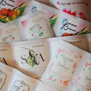 May include: A collection of wedding favor labels with various designs. The labels feature floral patterns, grapes, and text in Italian. Some labels include the names of the couples and the date of their wedding.